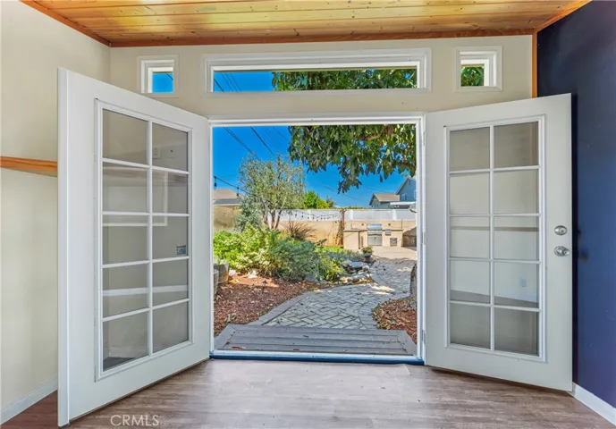 Charming backyard studio overlooking a peaceful pond beneath a mature avocado tree perfect as a home office, gym, creative space, or private retreat.