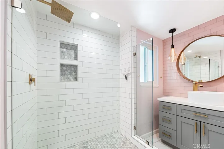 Designer bathroom featuring a custom vanity, statement mirror, and elegant designer finishes.