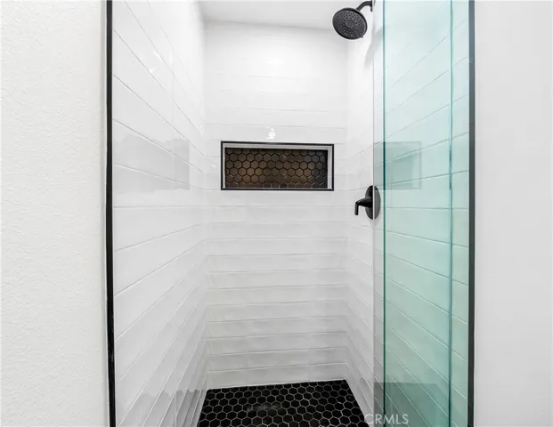 Designer vanity featuring a vessel sink, quartz countertops, matte black fixtures, and modern lighting.