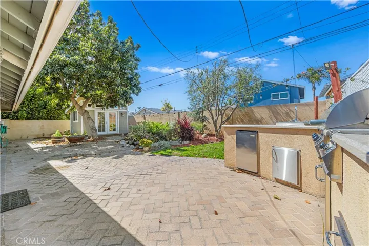 Entertainer's backyard featuring a built-in outdoor kitchen, BBQ, refrigerator, and plenty of room to relax and gather.