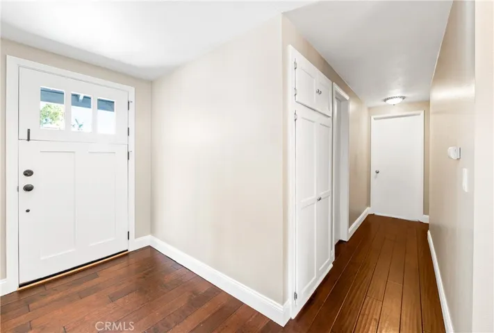 Welcoming entry featuring a charming custom Dutch door, rich wood flooring, and abundant natural light.