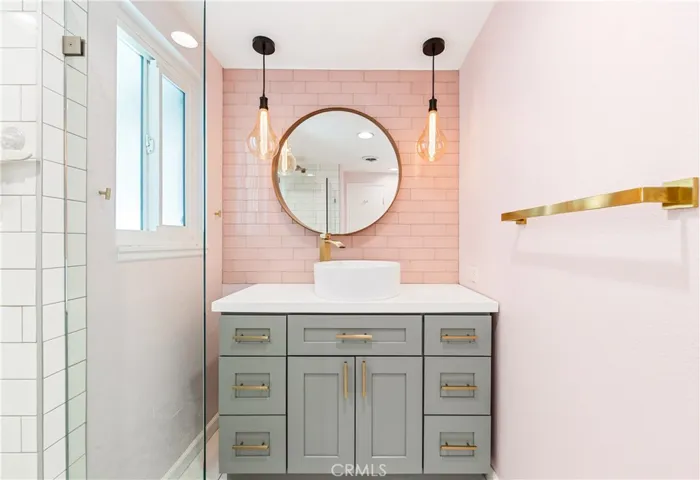 Designer bathroom featuring a custom vanity, statement mirror, and elegant designer finishes.