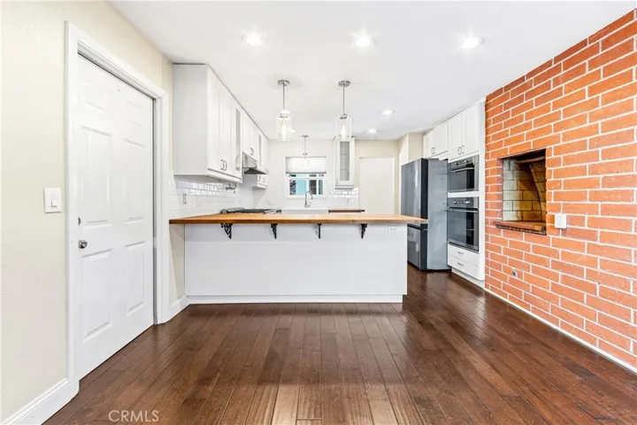 Open-concept living and dining areas flow seamlessly into the beautifully remodeled gourmet kitchen.