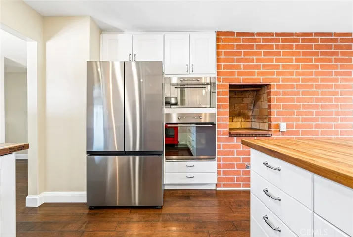 Beautifully remodeled kitchen showcasing designer finishes, built-in appliances, and an iconic indoor brick barbecue perfect for entertaining.