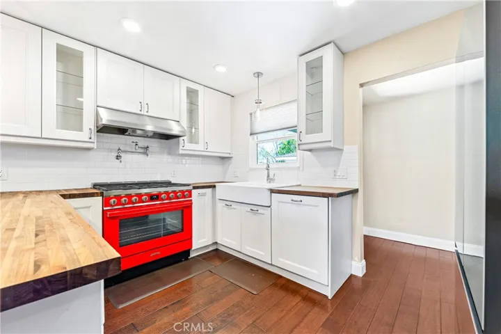Light-filled gourmet kitchen featuring a stunning 36" Smeg gas range, Williamsburg butcher block countertops, and abundant workspace.