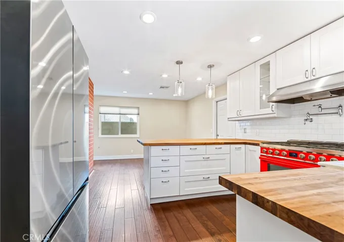 Light-filled gourmet kitchen featuring a stunning 36" Smeg gas range, Williamsburg butcher block countertops, and abundant workspace.
