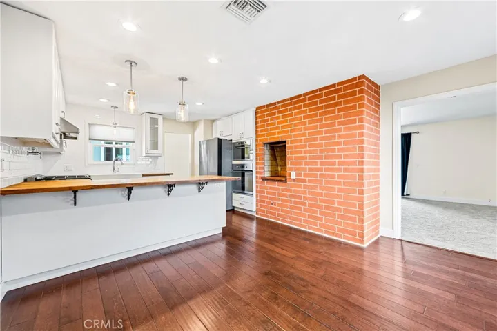 Beautifully remodeled kitchen showcasing designer finishes, built-in appliances, and an iconic indoor brick barbecue perfect for entertaining.