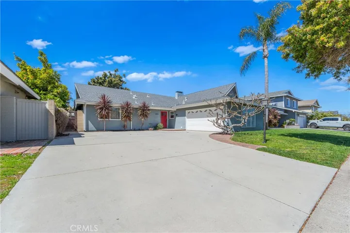 Exceptional curb appeal with an oversized driveway offering excellent RV or boat parking and a welcoming custom red entry door.