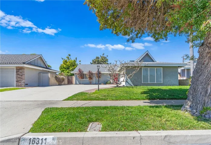 Exceptional curb appeal with an oversized driveway offering excellent RV or boat parking and a welcoming custom red entry door.