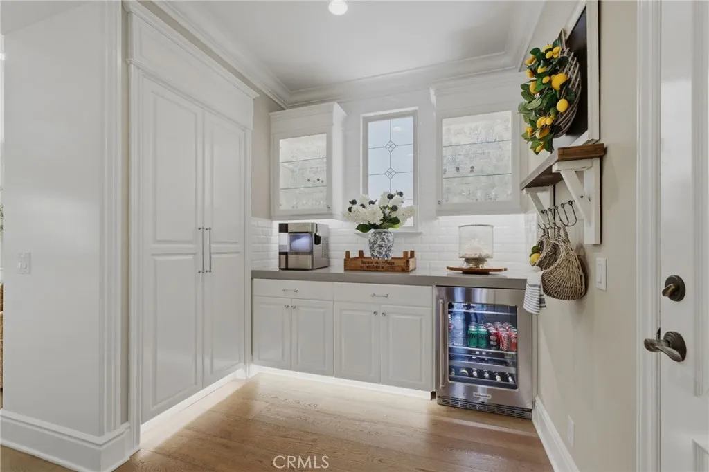 Butlers pantry with beverage fridge and custom storage cabinetry