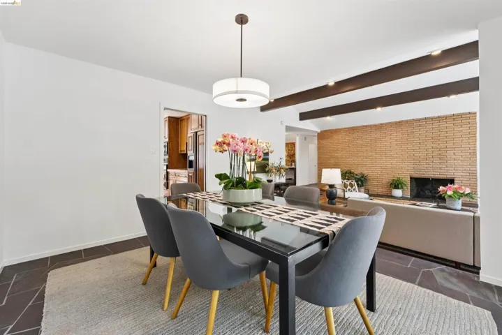 Open-concept dining area featuring dark slate flooring, a modern drum pendant light, and recessed lighting