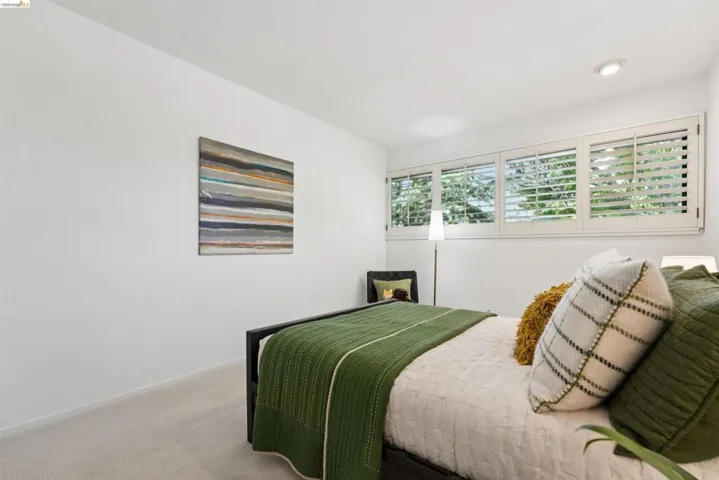 Wall-to-wall carpeting and white walls complement the recessed ceiling lighting