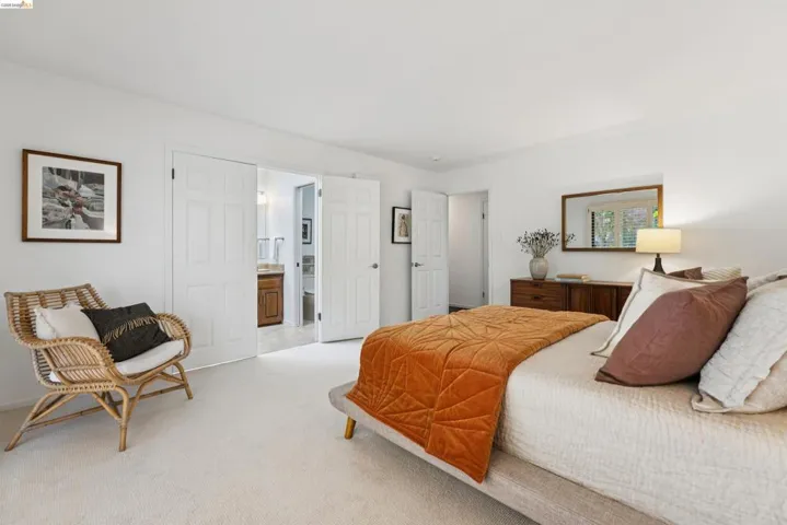 Carpeted bedroom featuring white walls and a large window with natural light