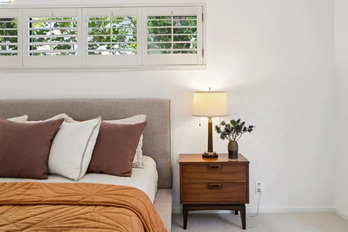 Upholstered headboard with an adjacent wood-finish nightstand