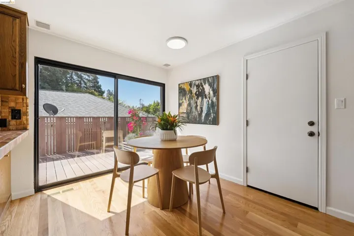 Dining area featuring wood-finish flooring, a contemporary ceiling light fixture, and a white interior door