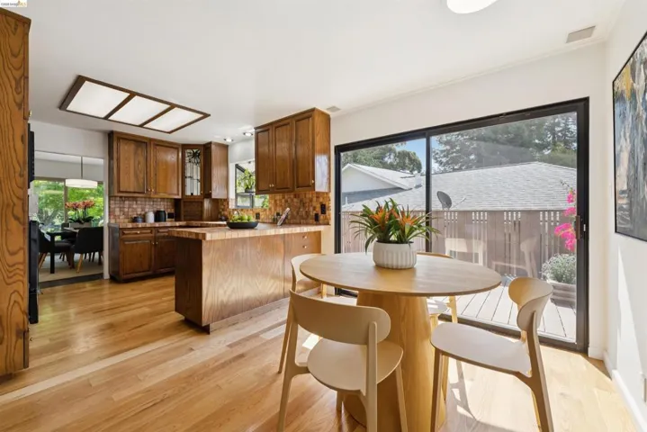 Kitchen featuring wood-finish cabinetry, light wood-finish flooring, and a tiled backsplash