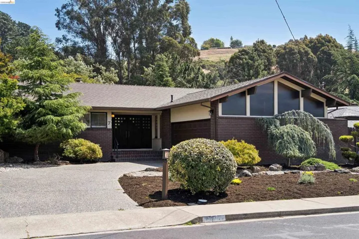 Mid-century modern exterior featuring a low-pitched roofline and brick facade