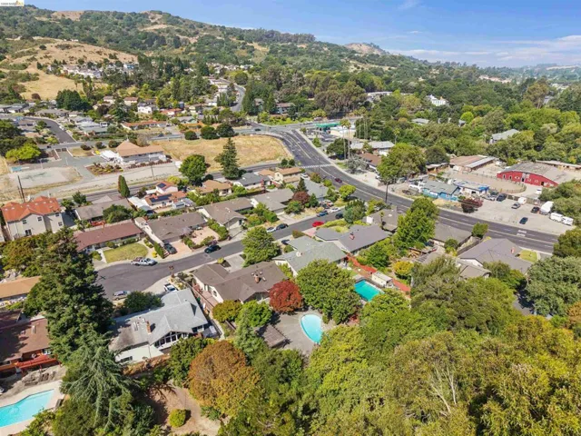Aerial perspective showcasing a residential area with varied rooflines and extensive tree coverage