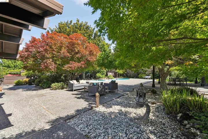 Expansive outdoor patio with concrete paving and decorative gravel accents
