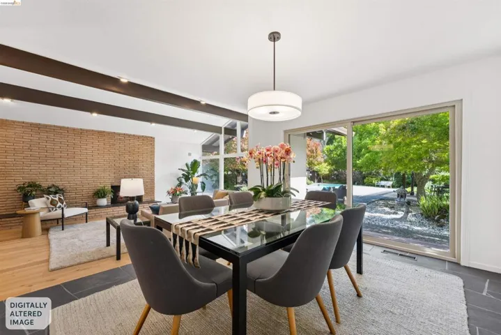 Dining area featuring a glass-top table, suspended pendant lighting, and sliding glass doors opening to the exterior