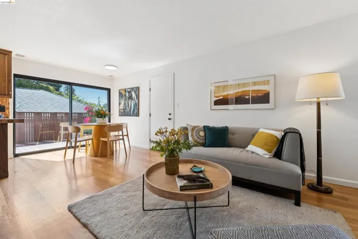 Open-concept living area with light-toned wood flooring and recessed lighting