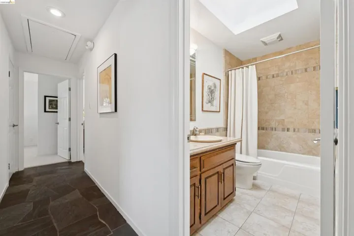 Hallway featuring dark flagstone-style flooring and recessed lighting