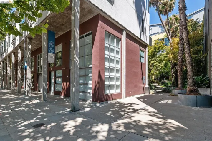 Modern architectural facade featuring concrete columns and a reddish-brown exterior
