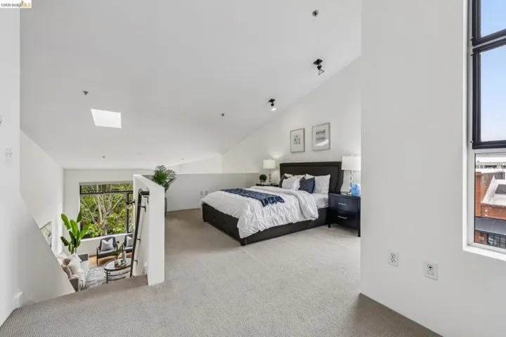 Loft bedroom featuring an angled ceiling, recessed lighting, and a skylight