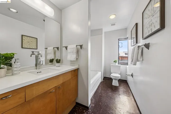 Contemporary bathroom featuring a light wood vanity with a white countertop and an integrated sink