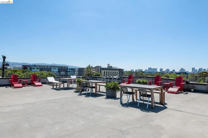 Expansive rooftop terrace with concrete flooring, framed by a low wall with metal railing