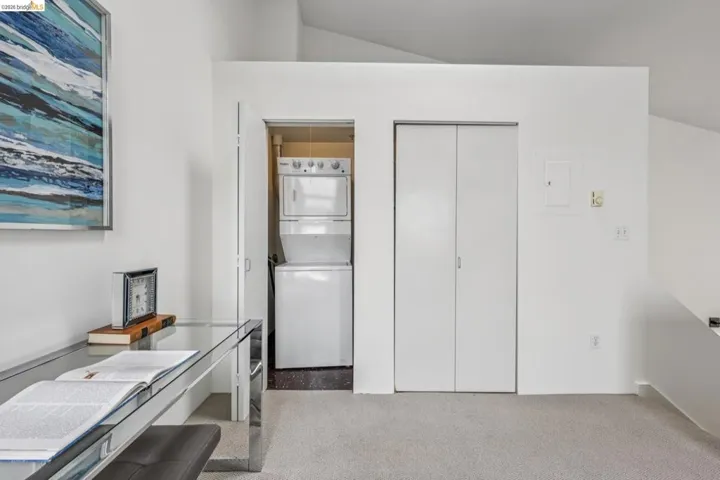 Integrated laundry area featuring a stacked washer and dryer unit