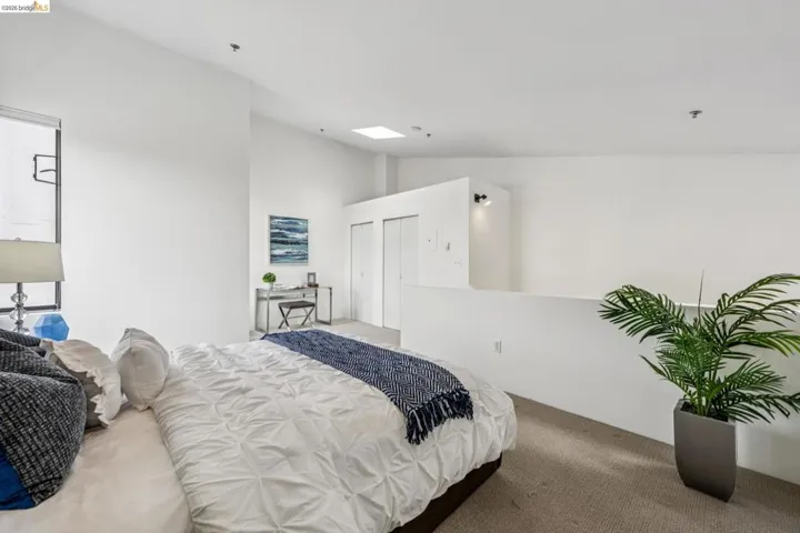 Open-concept room featuring high ceilings, a skylight, and wall-to-wall carpeting