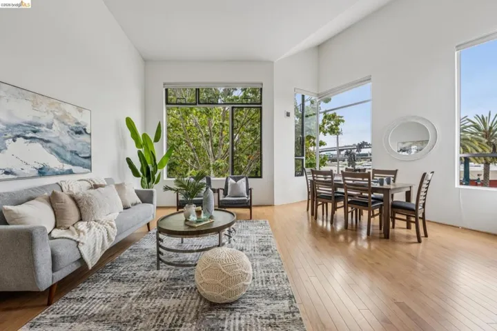 Open-concept living and dining area featuring high ceilings and light wood-finish flooring