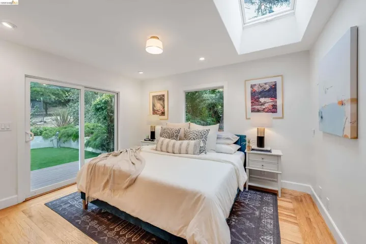 Skylight and recessed lighting illuminate this room featuring wood-finish flooring