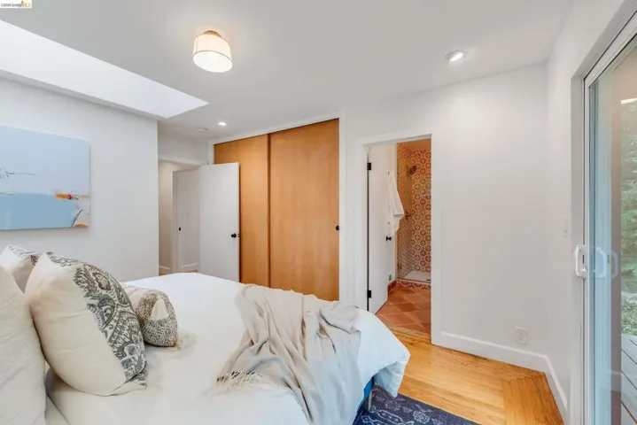 Bedroom with wood-finish flooring, a skylight, and recessed lighting