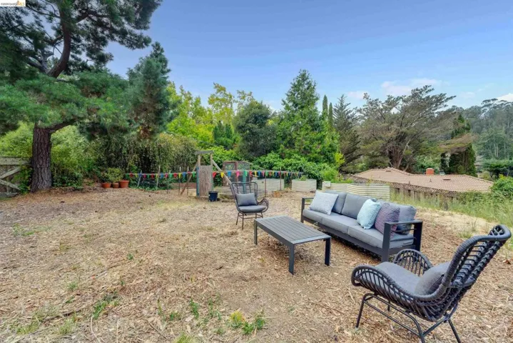 Expansive outdoor space featuring established trees and a garden area with raised beds
