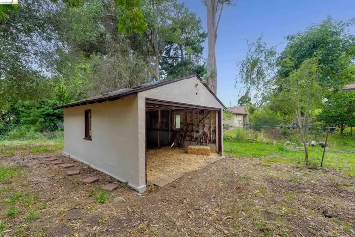 Detached outbuilding with stucco exterior and gable roof