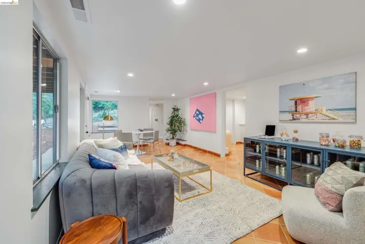 Open-concept living area featuring terracotta tile flooring and recessed lighting