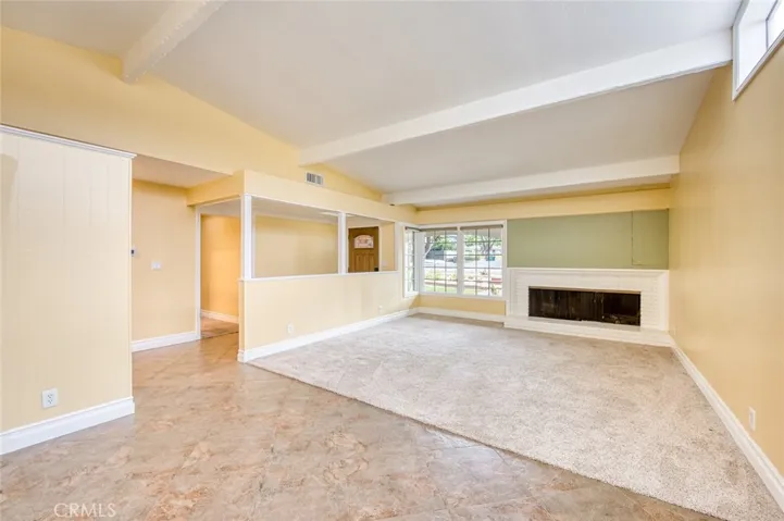 Step inside to a warm and inviting living room centered around a cozy fireplace that flows effortlessly into the formal dining area, creating an ideal setting for both entertaining and everyday living.