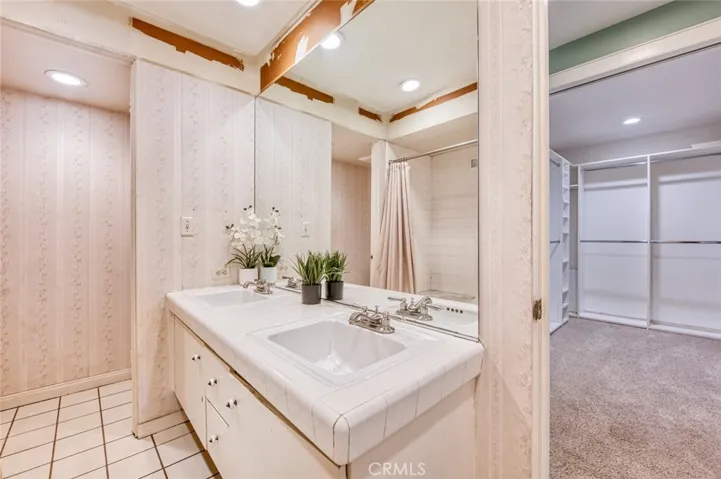 Primary en-suite bathroom with double sinks and custom oversized walk-in closet.
