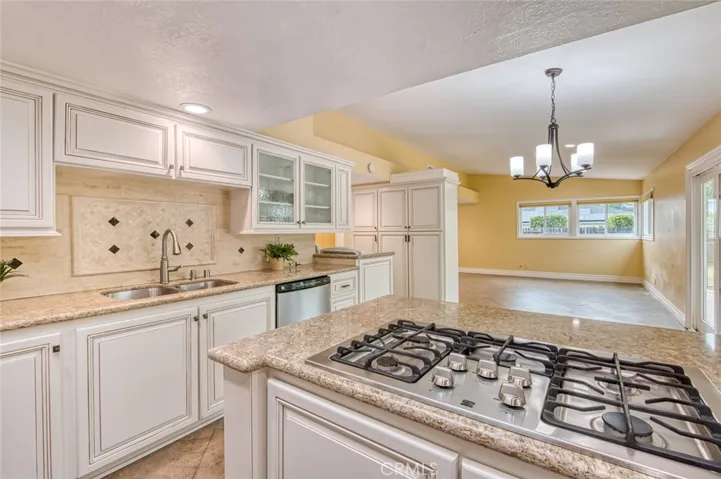 The remodeled kitchen features custom soft-close cabinetry and drawers, generous counter space, an adjoining casual dining area and open to the family room.