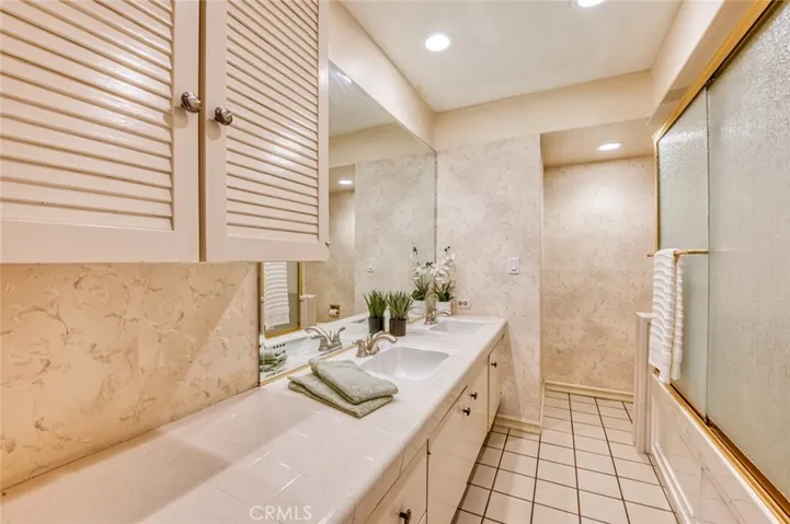 Hall bathroom with double sinks and tub/shower combo.