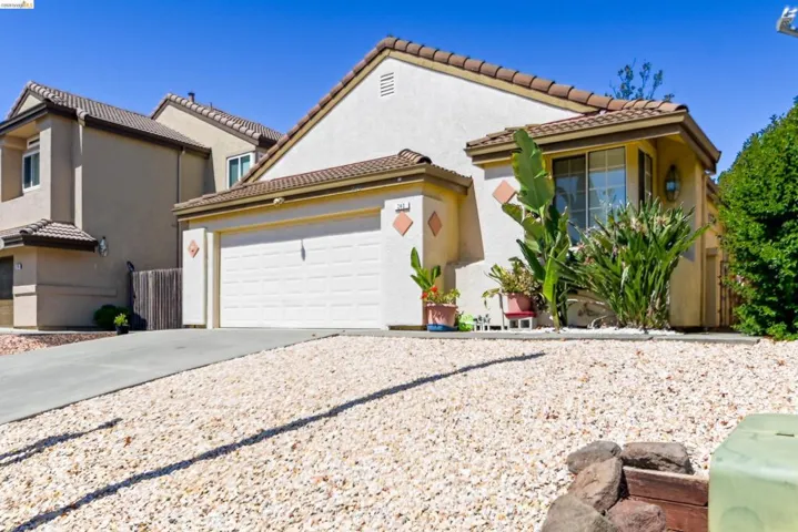 Stucco exterior residence with a concrete tile roof and an attached two-car garage