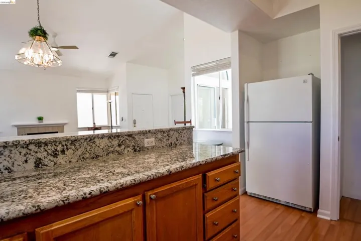 Kitchen pass-through featuring granite countertops and wood cabinetry