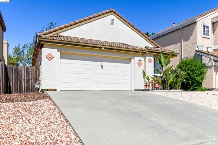 Stucco exterior with a tile roof and an attached two-car garage