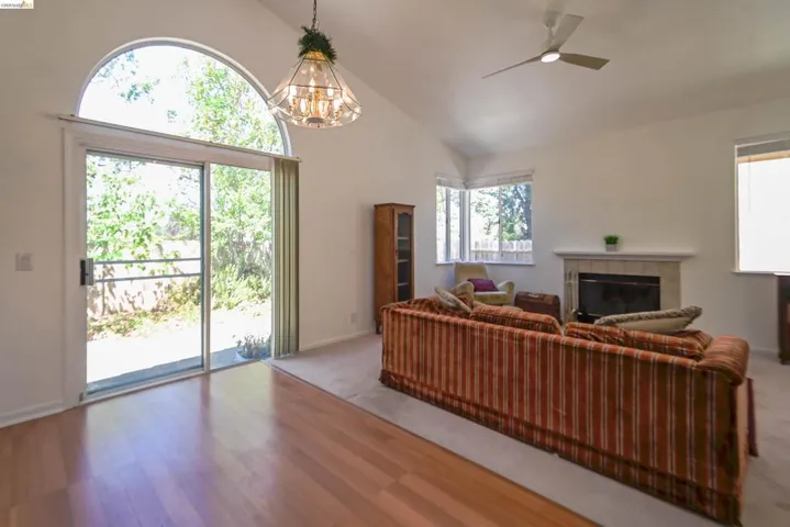 Living area featuring a vaulted ceiling and wood-finish flooring