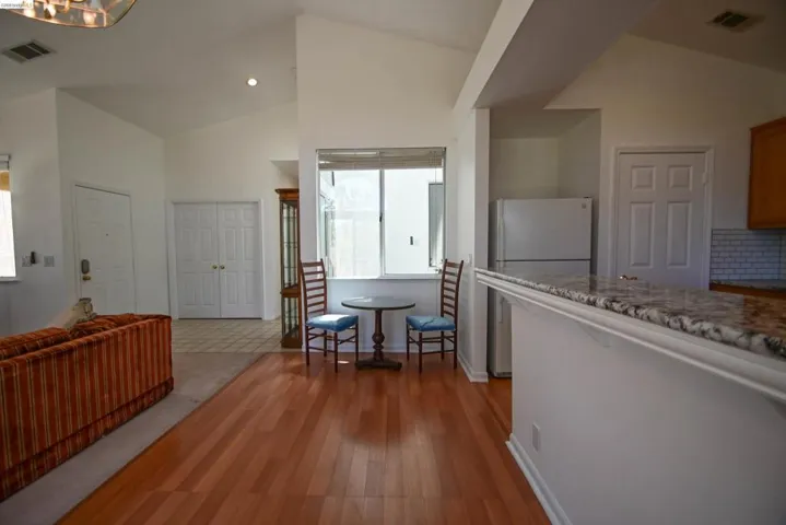 Open-concept living space featuring wood-finish flooring, vaulted ceilings, and recessed lighting