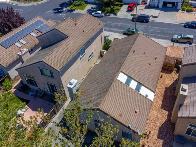 Aerial perspective showcasing two residential properties featuring tile roofs