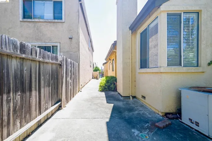 Concrete walkway bordering a wooden privacy fence