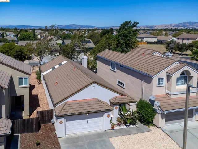 Aerial perspective showcasing two residential properties featuring stucco exteriors and tile roofing